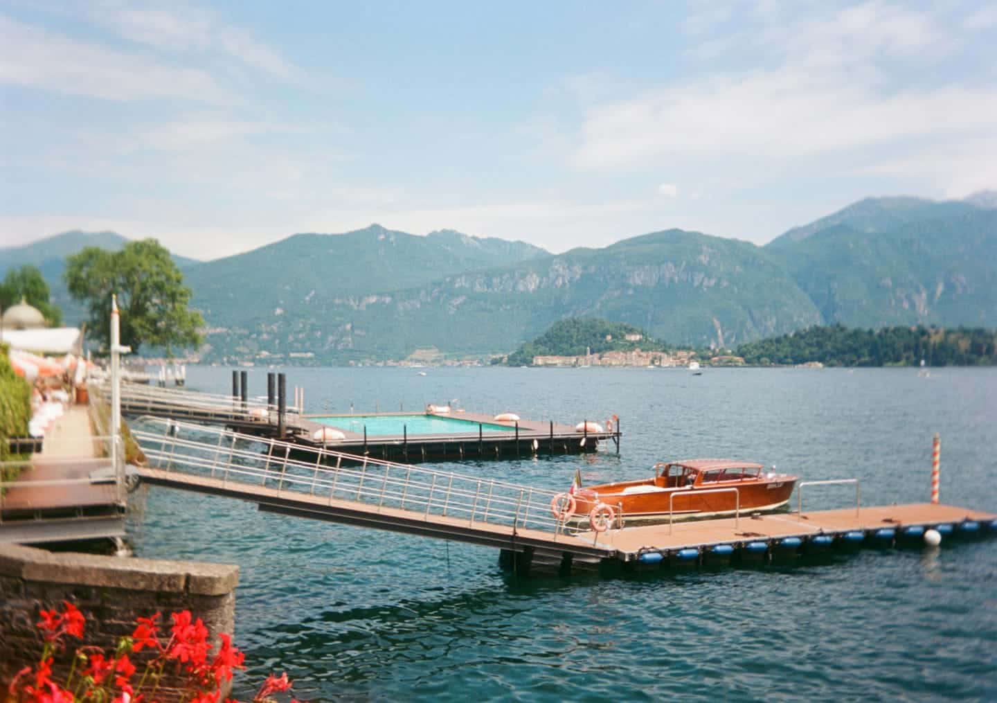 A jetty at the water's edge, with a small launch moored against it